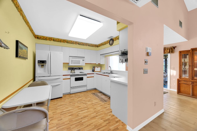 kitchen featuring white cabinetry, sink, light hardwood / wood-style floors, and white appliances