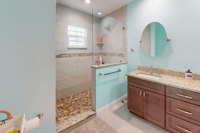 bathroom featuring tile patterned floors, vanity, and a tile shower