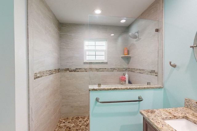 bathroom with vanity and tiled shower