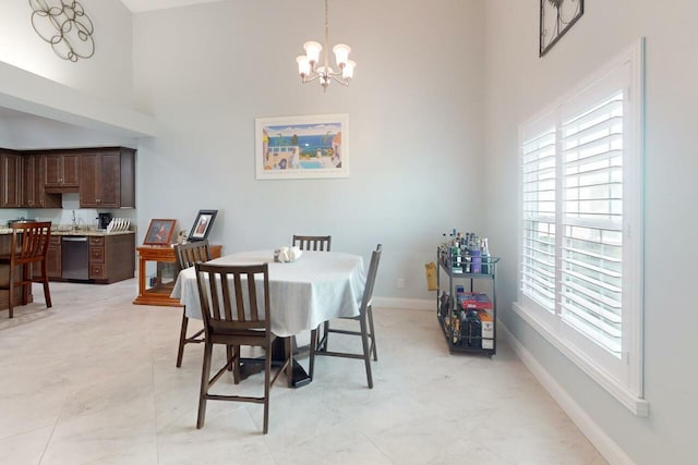 dining space with a towering ceiling and an inviting chandelier