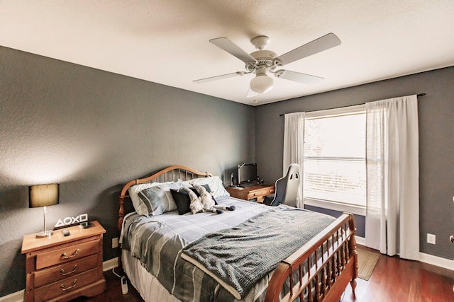 bedroom with dark hardwood / wood-style flooring and ceiling fan