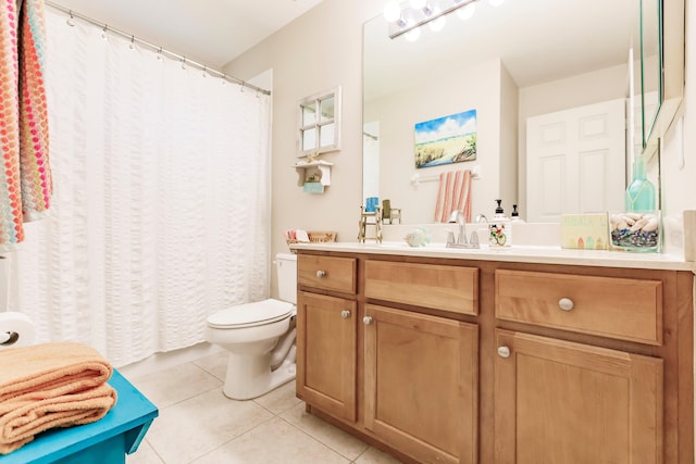 bathroom with toilet, vanity, and tile patterned floors