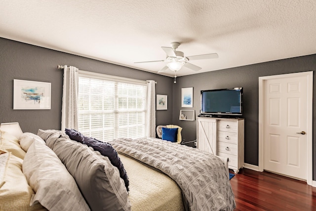 bedroom with ceiling fan, dark hardwood / wood-style flooring, and a textured ceiling