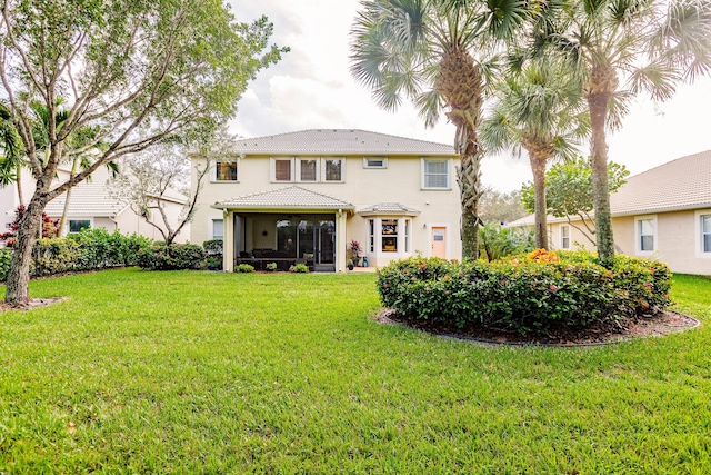 back of house with a sunroom and a yard