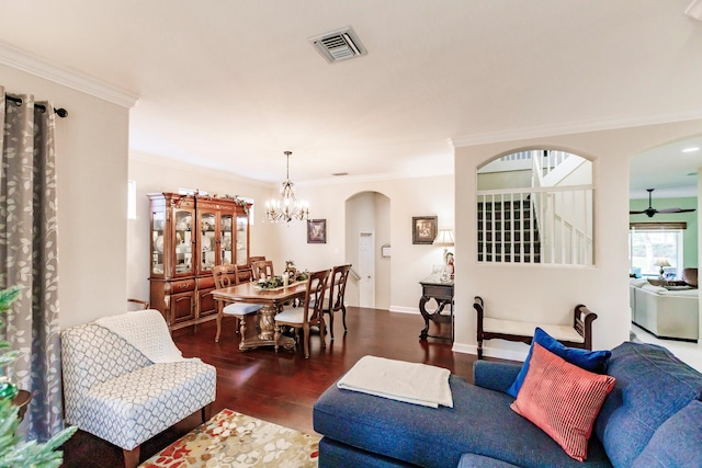 living room featuring ceiling fan with notable chandelier, dark hardwood / wood-style flooring, and crown molding