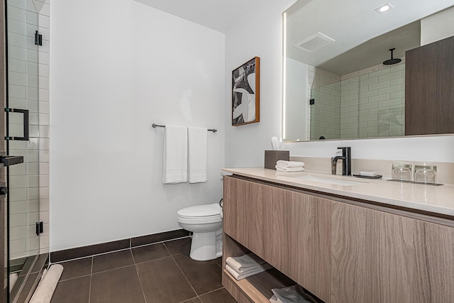 bathroom featuring tile patterned flooring, vanity, toilet, and an enclosed shower