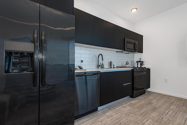 kitchen with tasteful backsplash, light hardwood / wood-style flooring, stainless steel appliances, and sink