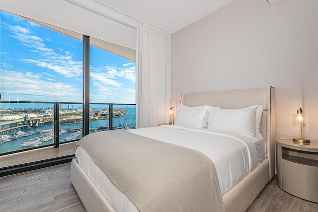 bedroom featuring light hardwood / wood-style floors and a water view