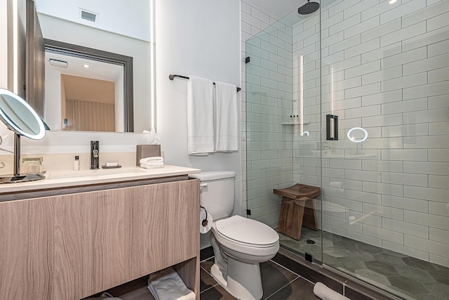 bathroom with toilet, vanity, tile patterned floors, and walk in shower