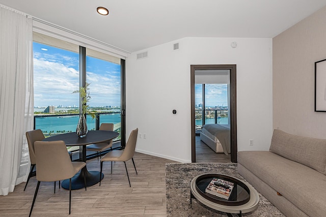 dining area featuring light hardwood / wood-style floors and a water view