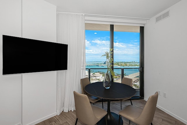 dining room featuring a water view and wood-type flooring