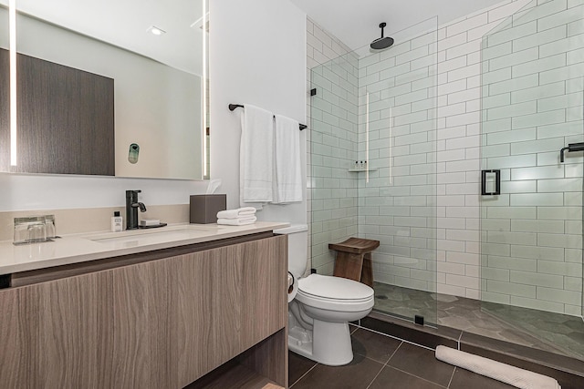 bathroom featuring tile patterned flooring, vanity, toilet, and a shower with shower door