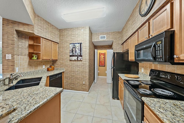 kitchen featuring light stone countertops, a textured ceiling, sink, and black appliances