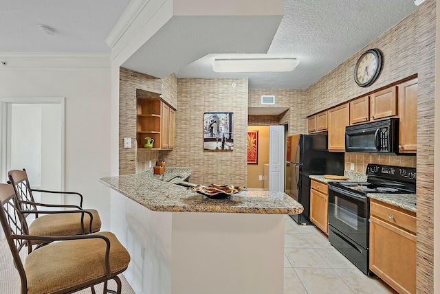 kitchen with kitchen peninsula, a kitchen bar, light stone counters, ornamental molding, and black appliances