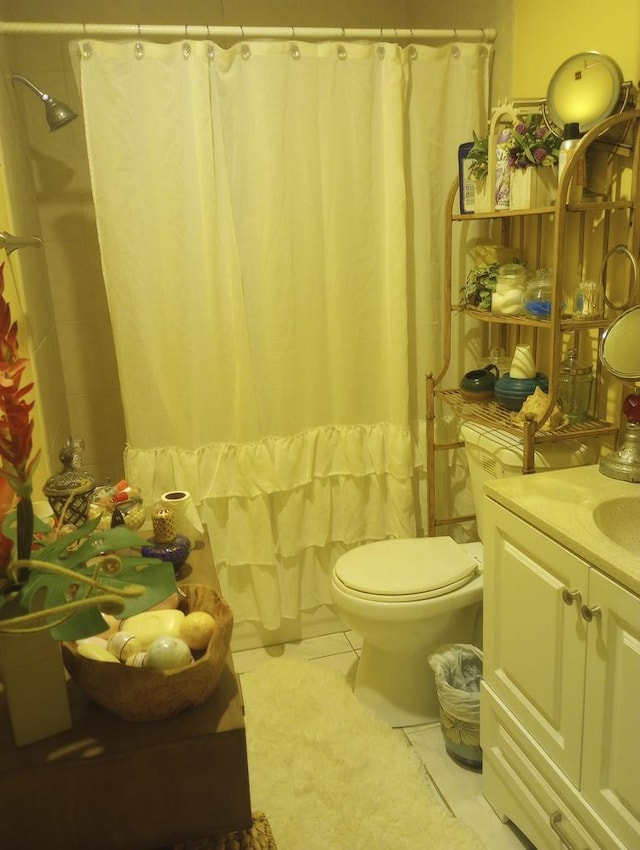 bathroom with toilet, vanity, and tile patterned floors