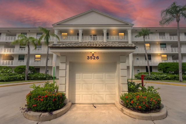 view of front of property featuring a balcony and a garage