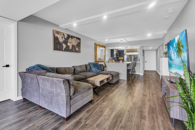 living room featuring beamed ceiling and dark hardwood / wood-style floors