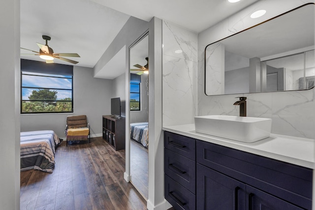 bathroom featuring decorative backsplash, ceiling fan, vanity, and wood-type flooring