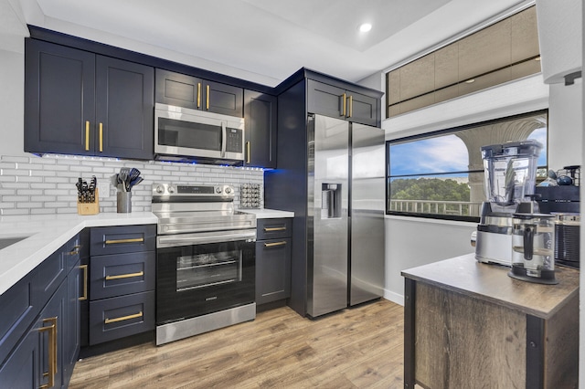 kitchen with tasteful backsplash, stainless steel appliances, and light hardwood / wood-style floors