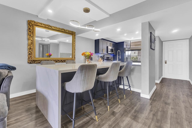 kitchen with kitchen peninsula, a kitchen breakfast bar, stainless steel appliances, and blue cabinets