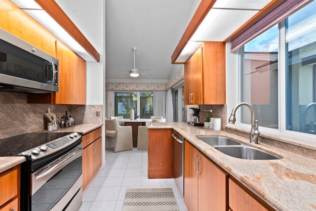 kitchen with ceiling fan, decorative backsplash, sink, and appliances with stainless steel finishes