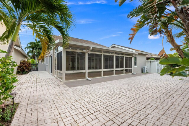 rear view of property with a patio and a sunroom