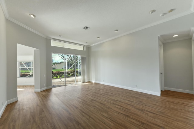 empty room featuring crown molding, baseboards, a wealth of natural light, and wood finished floors