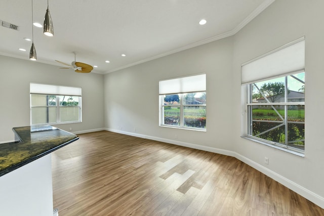 spare room featuring ornamental molding, wood finished floors, visible vents, and baseboards