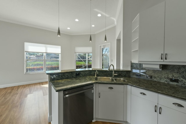 kitchen with dishwashing machine, dark stone countertops, ornamental molding, and a sink