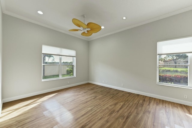 spare room with ornamental molding, baseboards, and wood finished floors