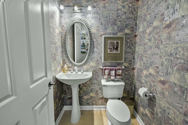 bathroom featuring toilet and baseboards