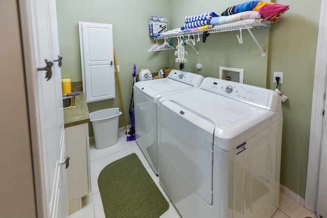 laundry area with laundry area, light tile patterned floors, baseboards, and washing machine and clothes dryer