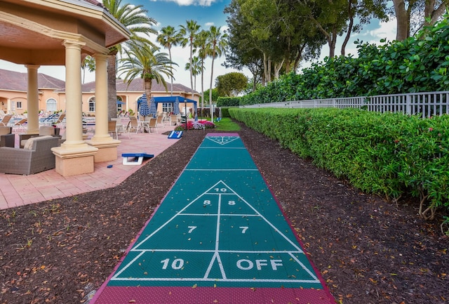 view of property's community featuring fence and shuffleboard