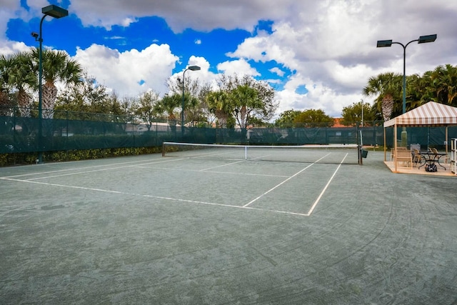 view of tennis court featuring fence