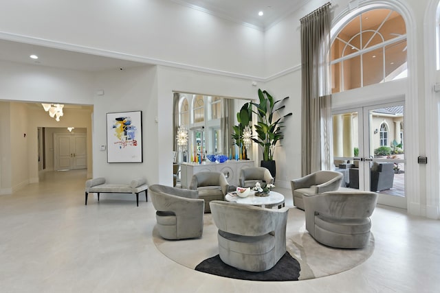 living area with recessed lighting, a high ceiling, baseboards, french doors, and crown molding