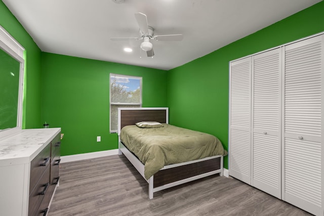 bedroom featuring ceiling fan, light hardwood / wood-style floors, and a closet