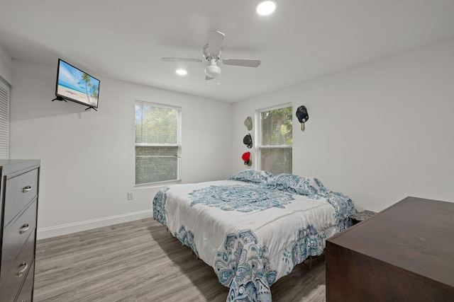 bedroom featuring hardwood / wood-style flooring, multiple windows, and ceiling fan