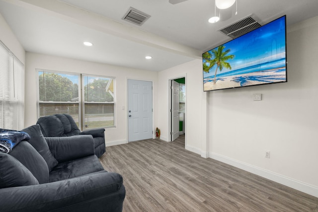 living room with beamed ceiling, ceiling fan, and wood-type flooring