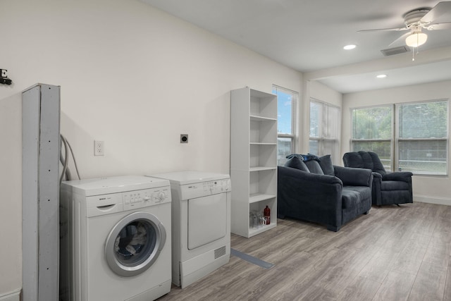 laundry area featuring washer and clothes dryer, ceiling fan, and light hardwood / wood-style floors