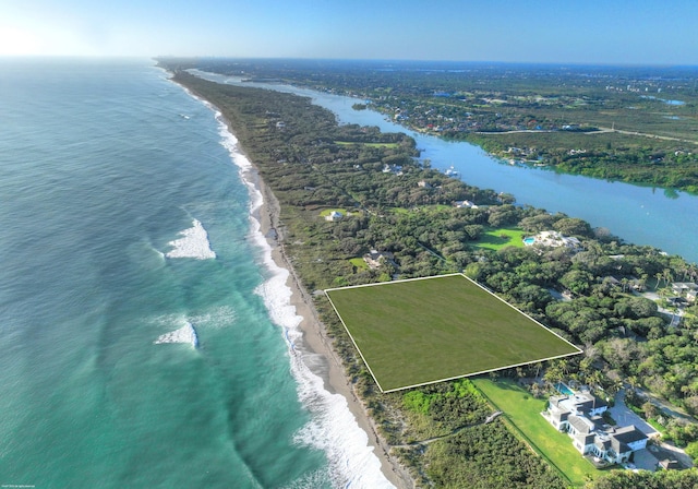 drone / aerial view featuring a beach view and a water view