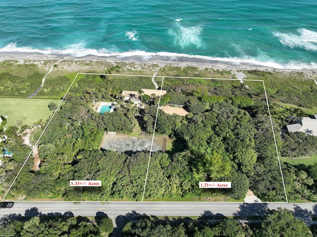 birds eye view of property with a water view and a view of the beach