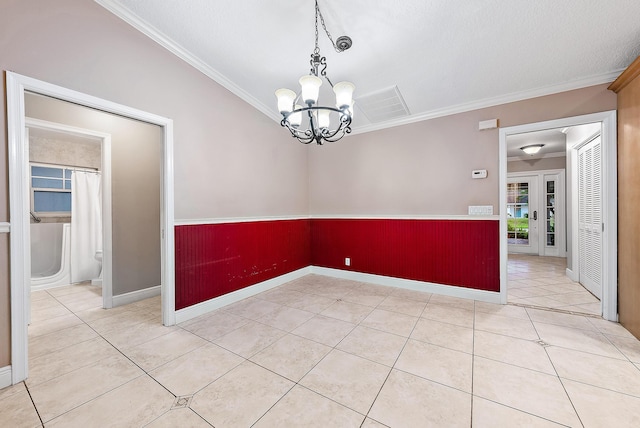 tiled empty room with crown molding and a chandelier