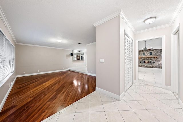 unfurnished living room featuring ornamental molding, light tile patterned floors, a textured ceiling, and a fireplace