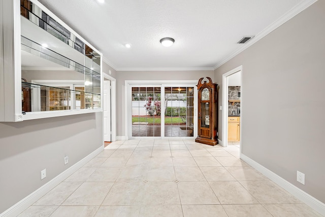 interior space with light tile patterned flooring, ornamental molding, and a textured ceiling