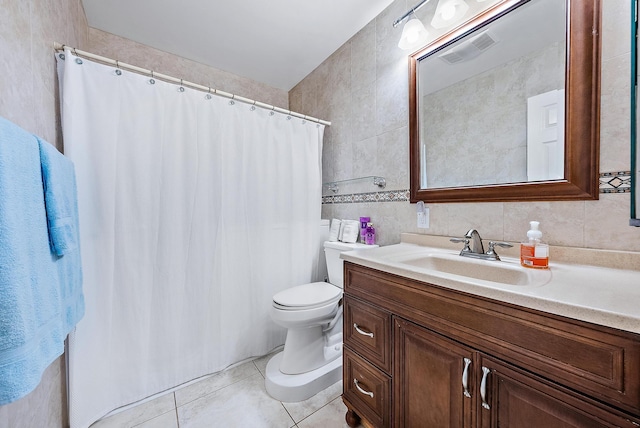 bathroom with tasteful backsplash, tile walls, vanity, toilet, and tile patterned floors