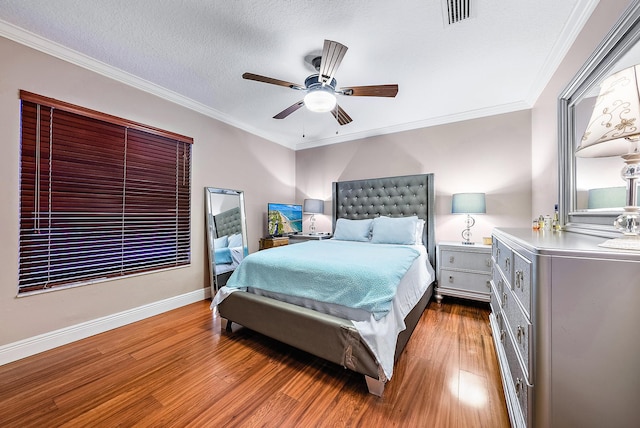 bedroom with wood-type flooring, a textured ceiling, ceiling fan, and ornamental molding