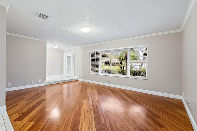 unfurnished room with wood-type flooring, ornamental molding, and a textured ceiling