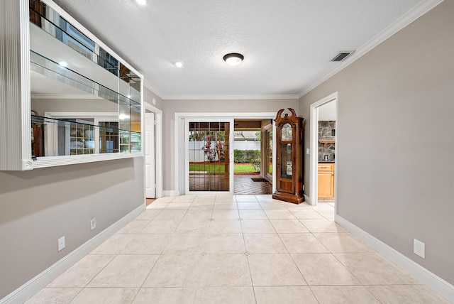 foyer featuring light tile patterned floors, a textured ceiling, and crown molding