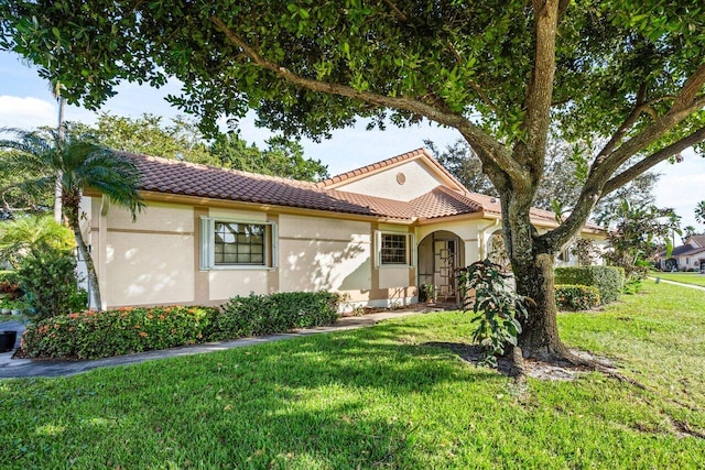 mediterranean / spanish-style house with a front yard