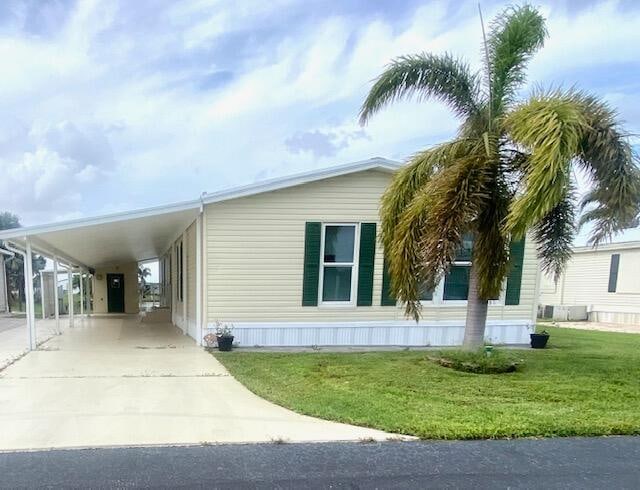 view of side of property with a yard and a carport